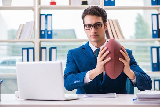 Businessman with american football in office