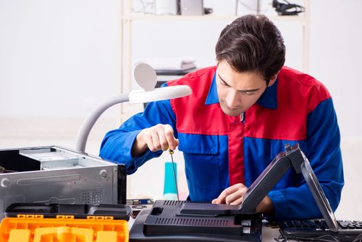 Professional repairman repairing computer in workshop