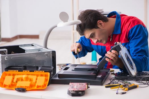 Professional repairman repairing computer in workshop