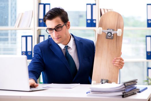 Businessman with skateboard in office