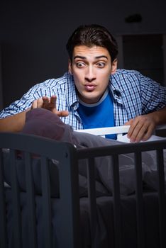 Happy dad looking after newborn baby at night