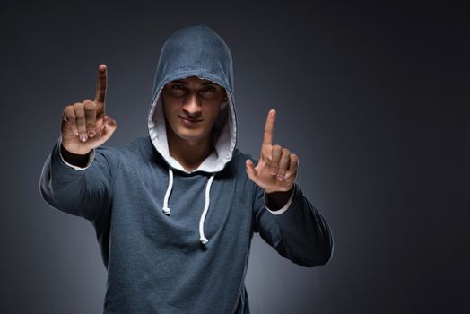 Young man wearing hoodie pressing virtual buttons