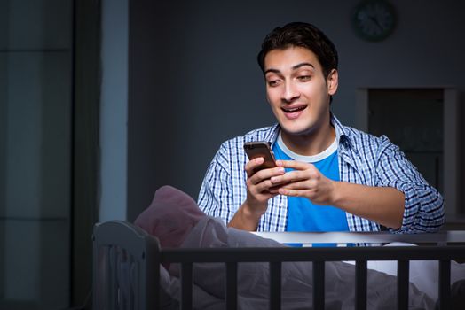 Happy dad looking after newborn baby at night