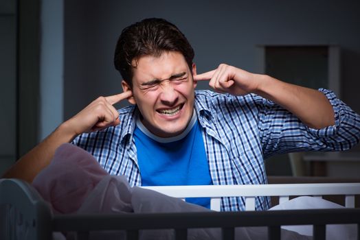 Young father under stress due to baby crying at night