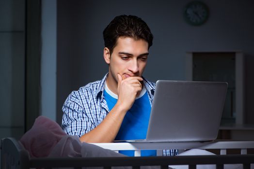 Young student doing homework and looking after newborn baby