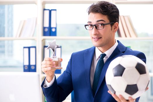 Businessman playing football in the office
