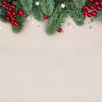 Traditional green christmas tree noble fir baubles berries and small decor border frame on craft paper background copy space for text