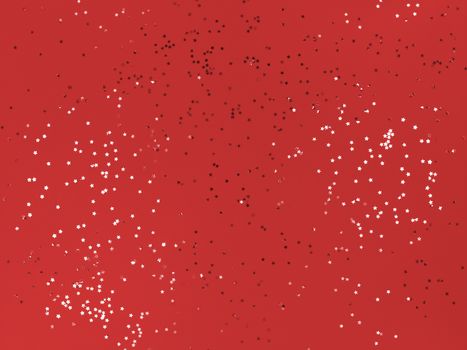 Confetti stars on red paper. Festive background.