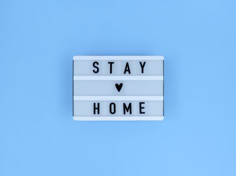 Light box with Stay home quote on blue background.