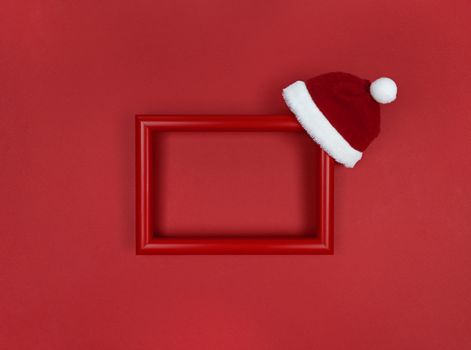 Frame and Santa hat on red background.
