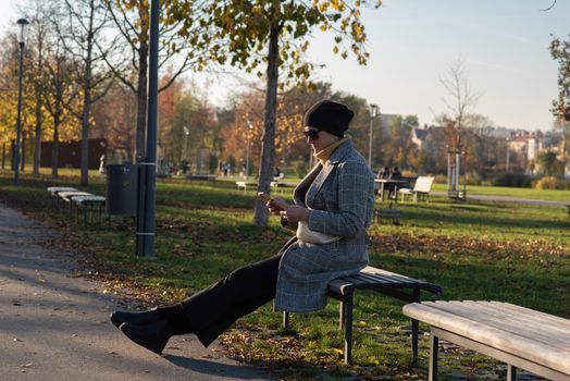 1/14/2020. Park Stromovka. Prague czech Republic. A woman is checking his phone in the park on a Sunday winter day.