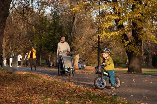 11/14/2020. Park Stromovka. Prague czech Republic. A kid is riding his motorbike in the companion of his father at the park on a Sunday winter day.