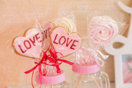 Sweets on a stick in a transparent glass jar valentine's day decoration.