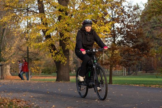 11/14/2020. Park Stromovka. Prague. Czech Republic. A woman is riding his bike at the park on a winter day.