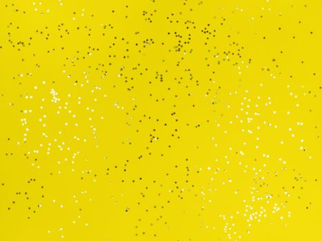 Confetti stars sparkling on yellow background.