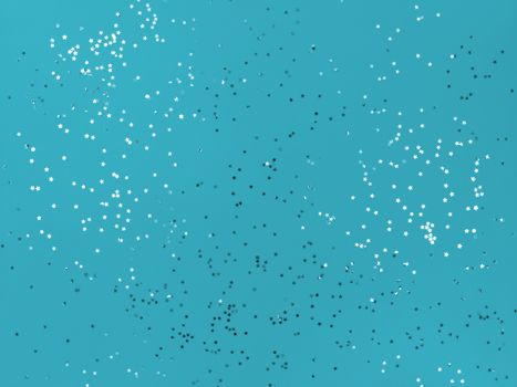 Confetti stars sparkling on blue background.