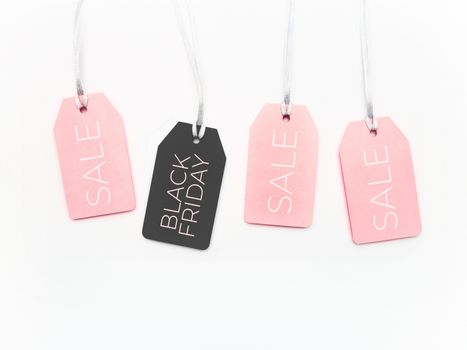 Pink and black tags on white background. Glamorous labels on silver threads. Black Friday sale and shopping. Top view, flat lay.