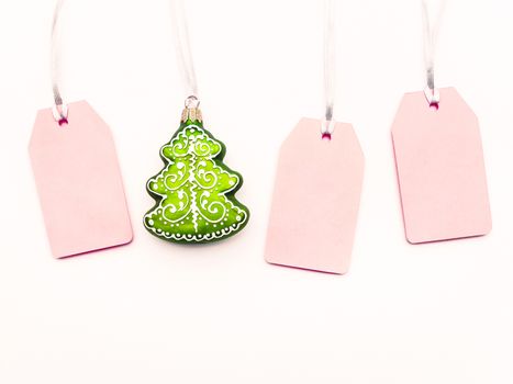 Three pink clear tags and decorative Chrsitmas tree on white background. Glamorous labels on silver threads with copy space. New Year symbol of sale and shopping. Top view, flat lay.