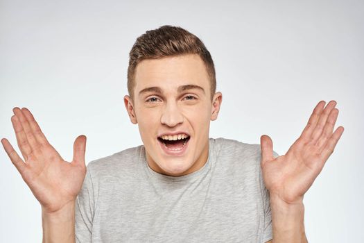 Handsome man in gray t-shirt cropped view of emotion Studio Model. High quality photo