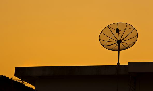Satellite on roof in the sunset.