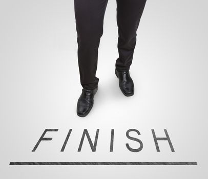 Businessman standing wearing court shoes on finish line.