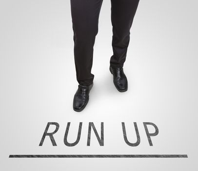 Businessman standing wearing court shoes on run up line.
