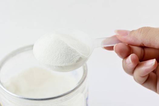 Collagen protein powder on spoon measure isolate on white background.