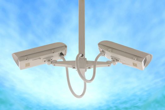Security twin side camera isolated on blue sky background.