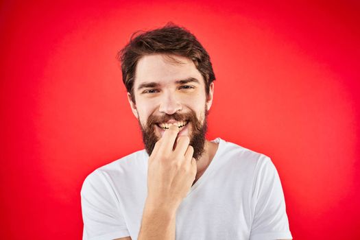 Bearded man fun emotions lifestyle cropped view white t-shirt red background. High quality photo