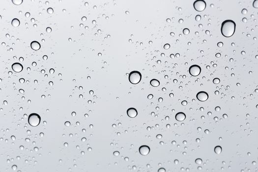 Water drop on glass mirror background.