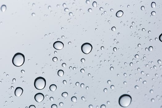 Water drop on glass mirror background.