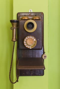 Antique vintage telephone green background.