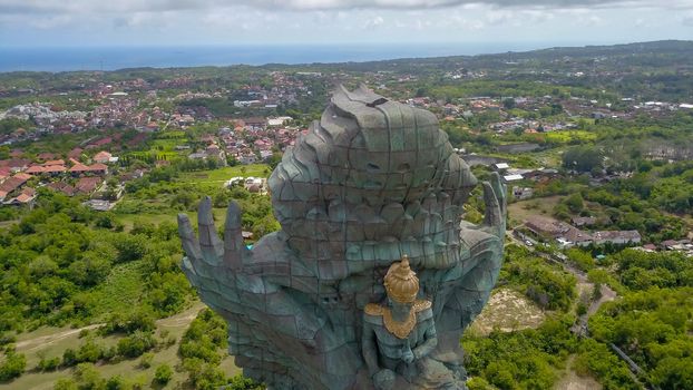Landscape picture of tallest Garuda Wisnu Kencana GWK statue as Bali landmark with blue sky as a background. Balinese traditional symbol of hindu religion. Popular travel destinations in Indonesia.