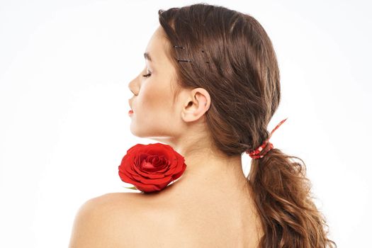 Portrait of woman with red rose naked shoulders Make-up on brunette face. High quality photo