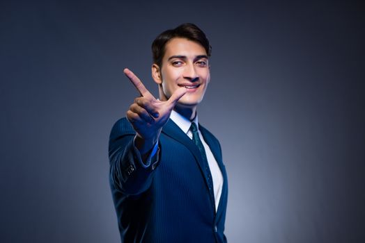 Businessman pressing virtual buttons on gray background