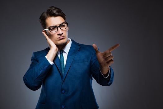 Businessman pressing virtual buttons on gray background