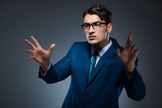 Businessman pressing virtual buttons on gray background