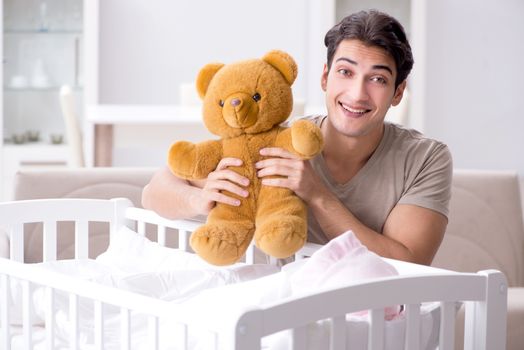 Young father enjoying time with newborn baby at home