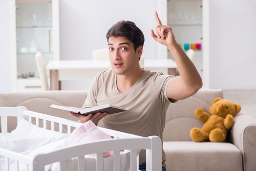 Young dad student preparing for exams and looking after baby