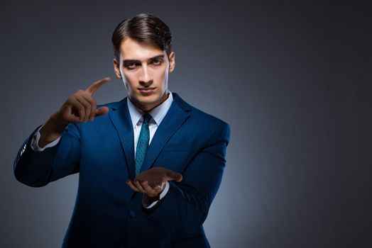 Businessman pressing virtual buttons on gray background