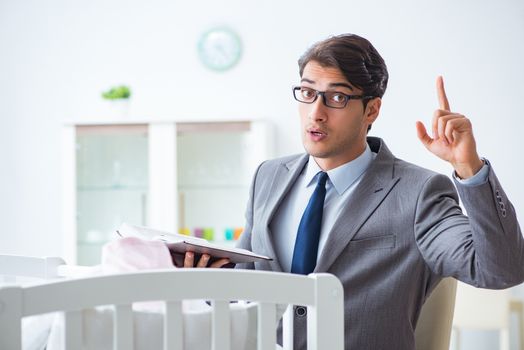 Young businessman trying to work from home caring after newborn baby