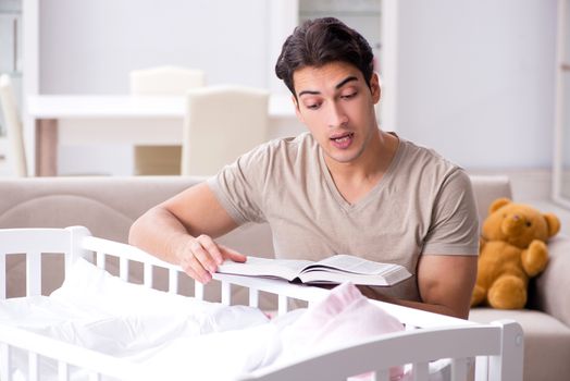 Young dad student preparing for exams and looking after baby