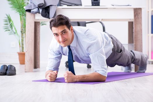 Businessman doing sports in office during break