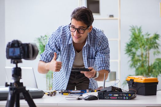 Vlogger recording computer repair on camera for vlog blog