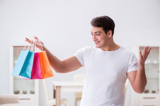Young man with gift bag at home preparing suprise for wife