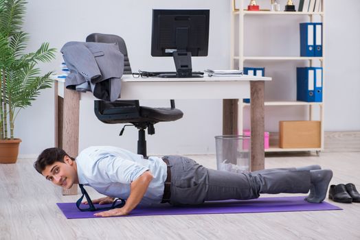 Businessman doing sports in office during break