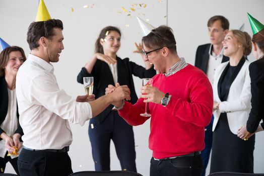 Business people drink champagne celebrating New Year at office party