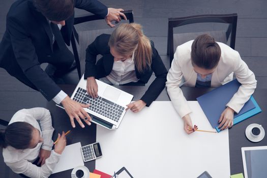 Business people at workplace, cup of coffee, digital tablet, smartphone, papers and various office objects on table, blanl white paper with copy space for text