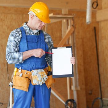 Worker showing document at construction site area, blank copy space for text