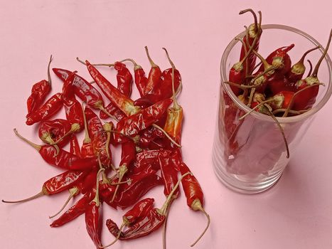 spicy and hot Dry Red Chilli stock on glass and pink background
